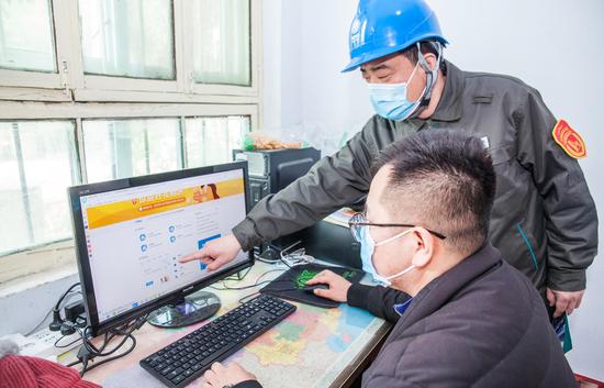 　辉县市供电公司服务人员向凯德化纤公司工作人员介绍如何河南通过电力大数据申请贷款。陈璞摄