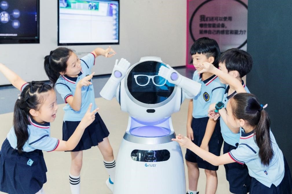 小学生们在杭州余杭人工智能教育基地和智能机器人互动