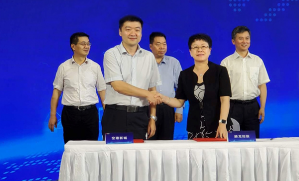 腾龙控股执行副总裁于靖、空港新城管委会副主任杨博在签约席合影